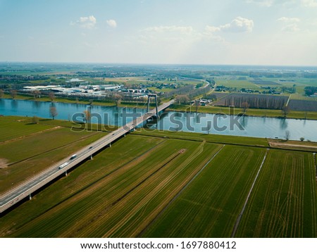 Aerial view of the canal, road, bridge and farm fields in the Netherlands. 