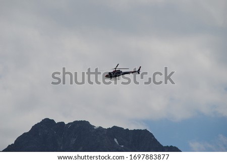 helicopter passing by a mountain