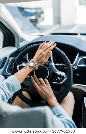 
Refined hands of a girl hold the steering wheel of a chic car. Modern interior of an expensive luxury car.
