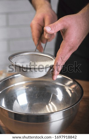 Man's hands sifting the flour. Cooking process of knead the dough