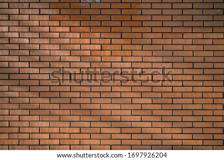 Red brick wall with rays and shadows from the sun