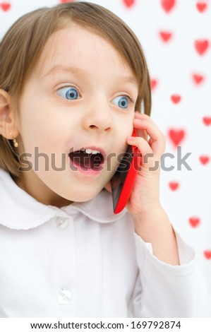 Happy little girl speaking by cell phone