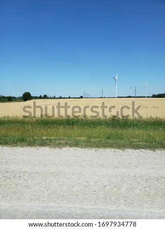 The golden wheat field with windmills along the highway provides a perfect picture stop