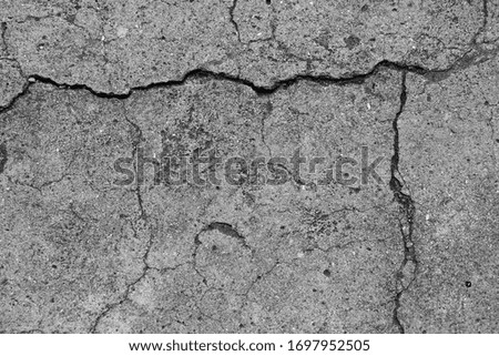 Close-up of cracks in grey concrete