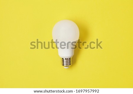 Energy saving light bulb on yellow back.