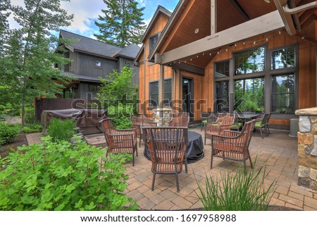 Beautiful large American Northwest home  exterior with brown wood in the forest with nice parge back yard patio