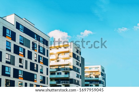 Detail in Modern residential flat apartment building exterior. Fragment of New luxury house and home complex. Part of City Real estate property and condo architecture. Copy space. Blue sky Royalty-Free Stock Photo #1697959045
