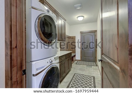 Laundry room interior with white washer and dryer and rich dark 