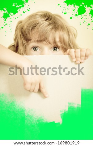 Child looking from behind the paper blank. Creative concept