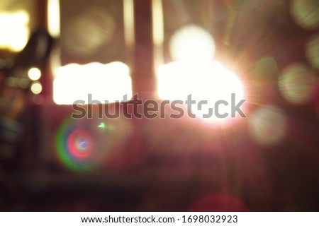 A purposefully blurry, de-focused background of blinding light shining through the window of a bedroom, casting warm light and colors. 