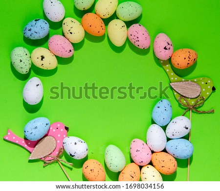 Festive frame of Easter eggs on a green background
