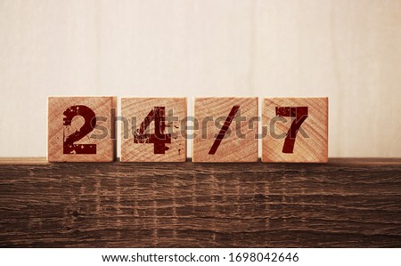 24/7 text on cubes on wooden background. Support clients concept.