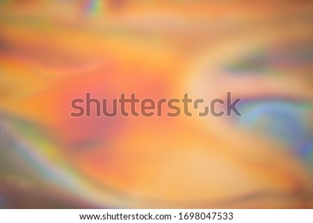 Abstract blurred holographic iridescent foil background. Wallpaper trendy gradient