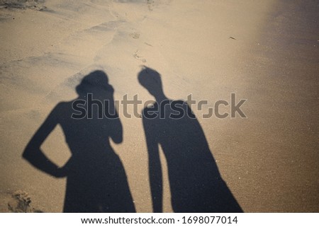 Two black shadows of girls on the beach sand