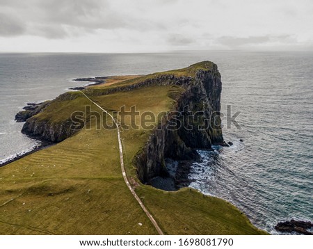 Aerial drone photo of Neist Point Lighthouse, Isle of Skye, Scotland. Cloudy day.