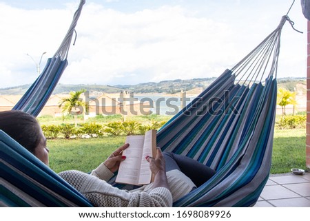 woman reading a book in hammock
