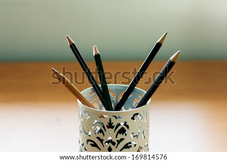 Many pencils in the box on the table
