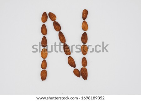 Letter N in uppercase made with almond nuts on a clean white background, capital letter lowercase