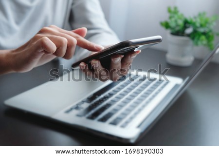 Blurred hand of woman is touch, slide, press on screen of phone for check e-mail, news, prepare of  meeting presentation, get promotion information for shopping online or operation of internet banking Royalty-Free Stock Photo #1698190303