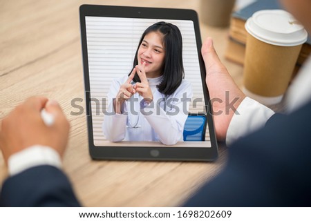 Close up of Business man sit at home having online consultation with doctor on Tablet,To reduce social distance healthcare concept