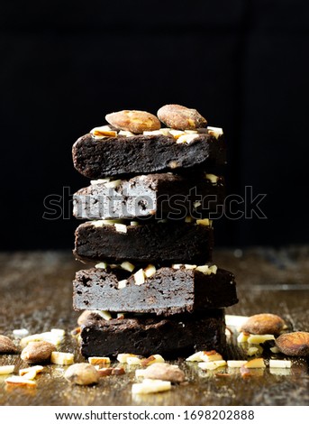 Black brownie almonds on wood table, close up picture. Food issue. 