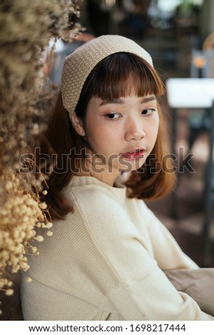 Portrait picture of gardener girl in a cafe and dry flowe ras a foreground.