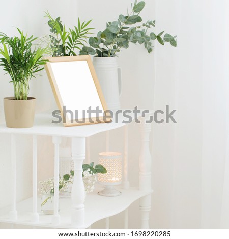 wooden frame on vintage white shelf with flowers and plants