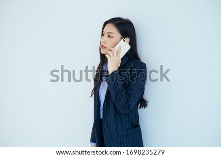 Young thai businesswoman using smartphone on white background.