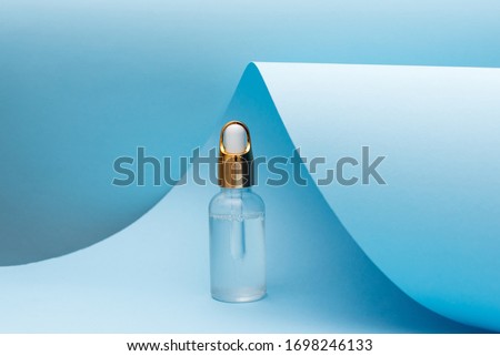 cosmetic oil bottle with pipette standing on blue background. skin care concept. Natural cosmetic. Modern beauty trend