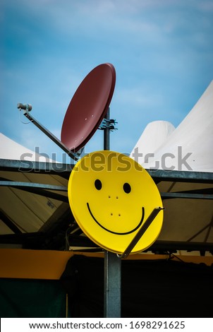 A smiley face painted on a satellite dish