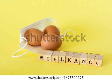 Eggs lying on face protection masks, "wielkanoc" means easter in polish