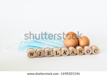 Eggs lying on face protection masks, "wielkanoc" means easter in polish