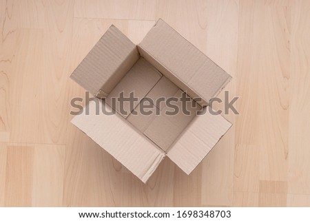 Empty open rectangular cardboard box on wood background. Shopping online object background. Shipping parcel object.
