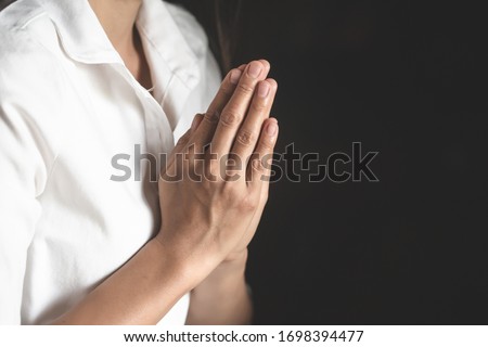 woman Praying hands with faith in religion and belief in God On the dark background. Namaste or Namaskar hands gesture, Pay respect, Prayer position. Royalty-Free Stock Photo #1698394477