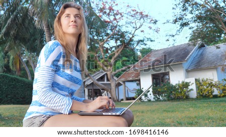 Young woman using laptop computer outdoor. Freelance work concept