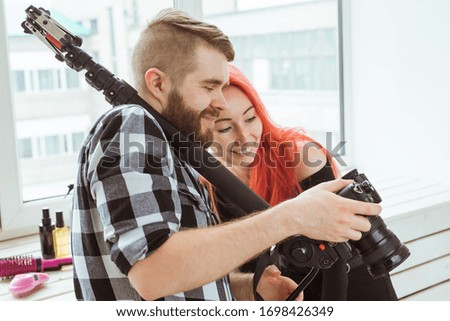 Video production, shooting advertising and content for social networks - Operator working with a camera on his shoulder and shows the girl footage.