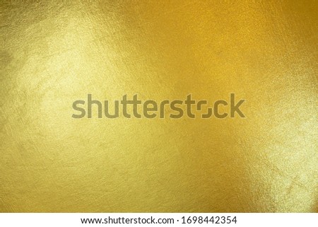 Gold texture background with yellow luxury shiny shine glitter sparkle of bright light reflection on golden surface, for celebration backdrop, wallpaper, Christmas decoration background or any design
