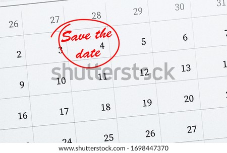 Paper calendar with phrase SAVE THE DATE, closeup