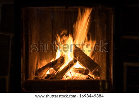 Roaring flames in a modern fireplace  Royalty-Free Stock Photo #1698449884