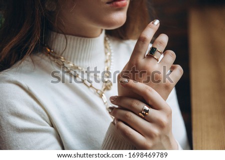 Woman's hands close up wearing rings and necklace modern accessories elegant lifestyle 2020 Royalty-Free Stock Photo #1698469789
