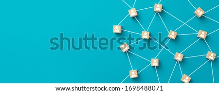 Wooden blocks connected together on blue background. Teamwork, network and community concept. Royalty-Free Stock Photo #1698488071