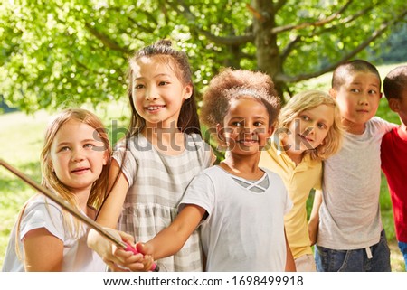 Group of multicultural kids in the park make selfie with selfie stick