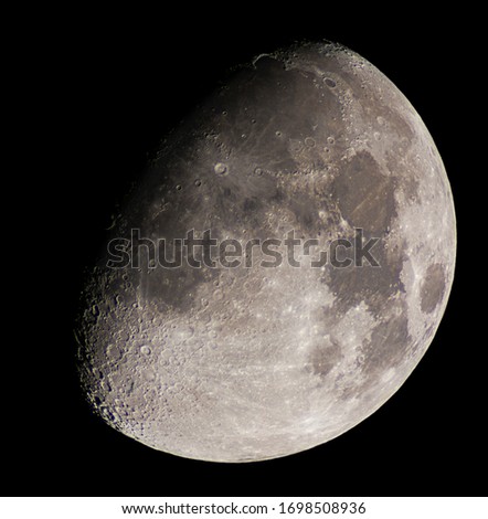 high resolution picture of the moon by telescope, with the moon illuminated at 75%