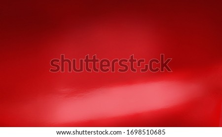 Red car body detail with light reflections