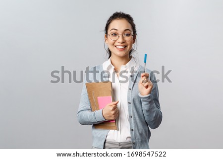Education, teachers, university and schools concept. Cute nerdy asian girl adding point, have solution to equation, raising pen to say her thought smiling, carry books and notebooks studying