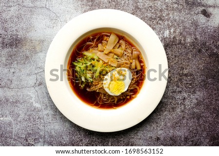 A flatlay picture of one rare traditional food from Malaysia call "mee belacan" on crack floor. A noodle eat together with squid and shrimp paste soup.