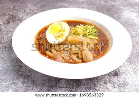 A picture of one rare traditional food from Malaysia call "mee belacan" on crack floor. A noodle eat together with squid and shrimp paste soup.