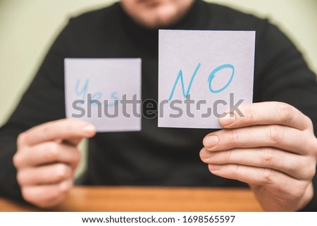Man holds two piece of paper