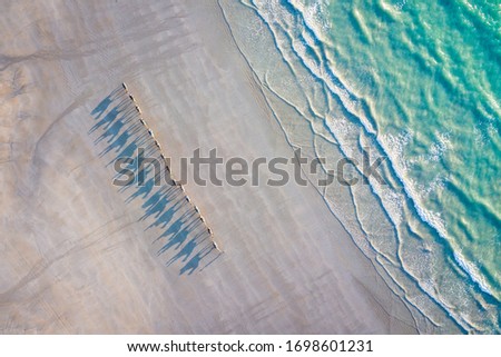 Camels walking along the beach during sunset, Cable Beach, Broome, Australia taken by a Drone Royalty-Free Stock Photo #1698601231