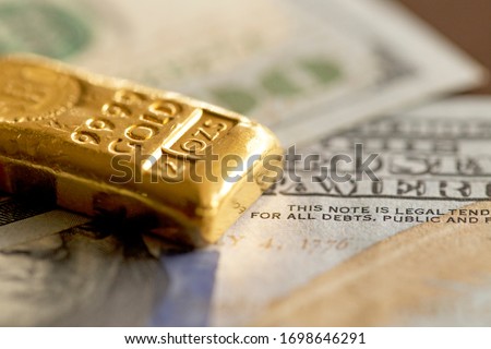 Gold Bullion on 100 US Dollar Note Royalty-Free Stock Photo #1698646291